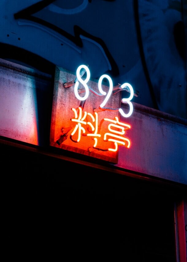 Close-up des schummrigen Neonschilds mit dem Restaurantnamen über dem unauffälligen Eingang des 893 Ryōtei.