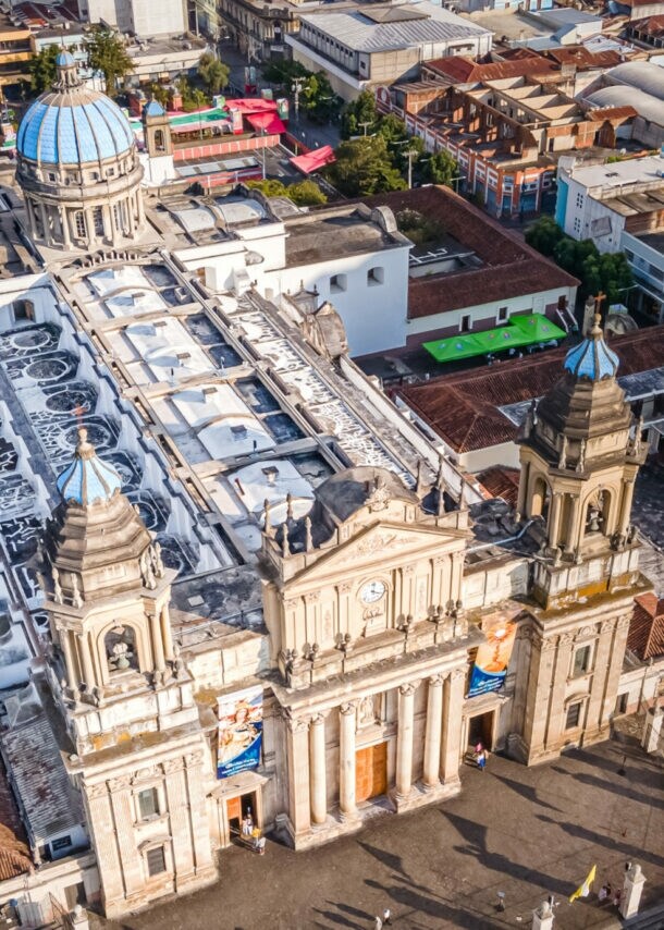 Luftaufnahme der Kathedrale von Guatemala-Stadt mit zwei Glockentürmen und blauem Kuppeldach im Stadtzentrum