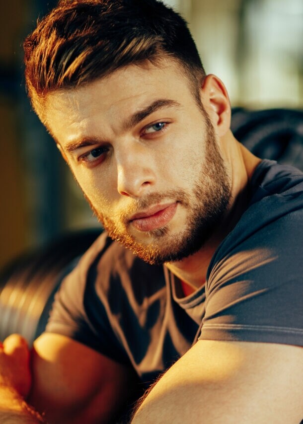 Ein Mann in Sportkleidung hält einen Protein-Shaker in der Hand.