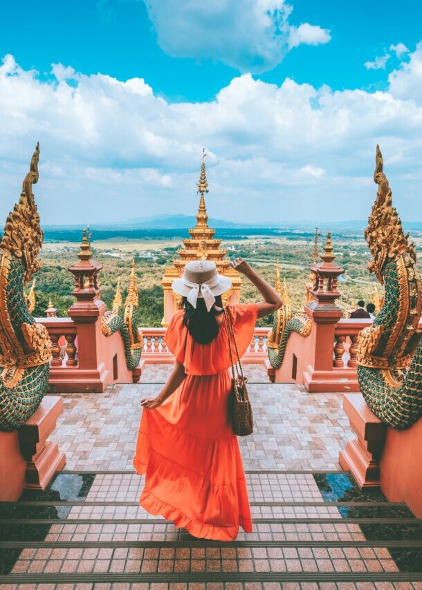 Eine Urlauberin steht in einer Tempelanlage in Thailand