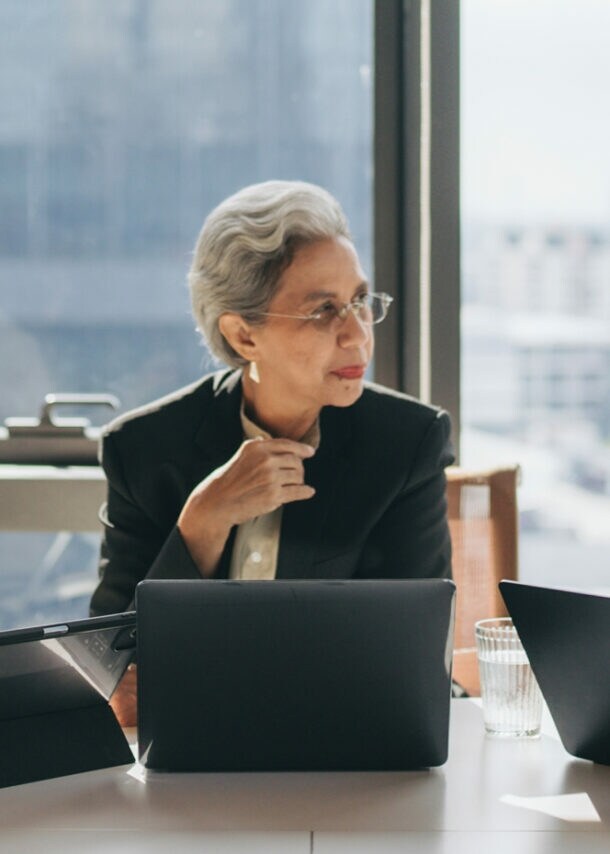 Teamgeist: Eine Gruppe von Frauen verschiedener Altersgruppen tauscht sich in einem hellen Meetingraum aus.