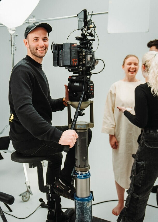 Fotografie von Dennis Schmelz an der Kamera im Filmstudio.