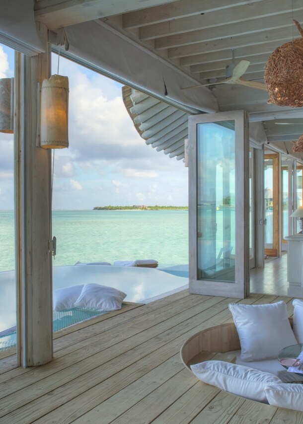 Luxuriöse Terrasse mit Sitzgarnitur einer Hotelsuite am türkisblauen Meer.