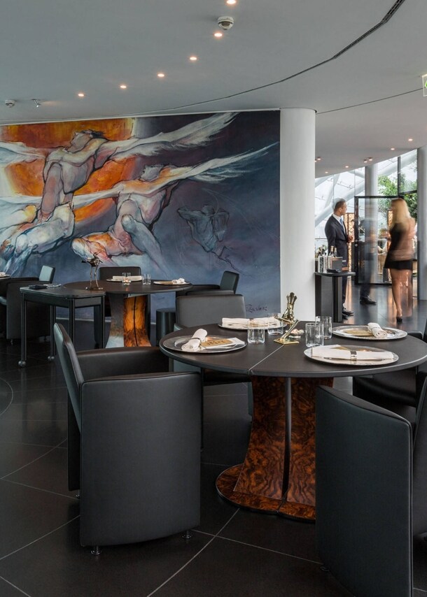 Stehende Personen in einem modernen Restaurant in einem lichtdurchfluteten Gebäude mit Glaskuppel.