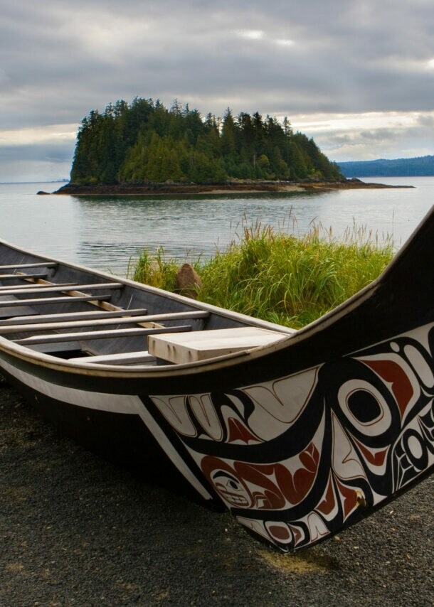 Ein traditionell bemaltes Kanu ruht an der Küste von Haida Gwaii.