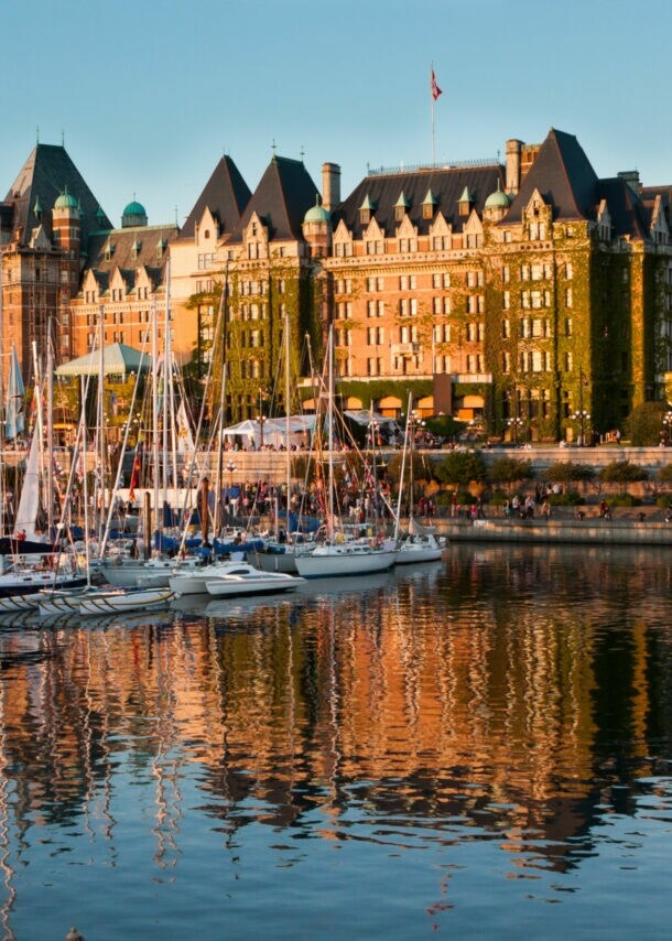 Boote vor dem historischen Fairmont Empress Hotel im Inner Harbour an einem klaren sonnigen Tag.