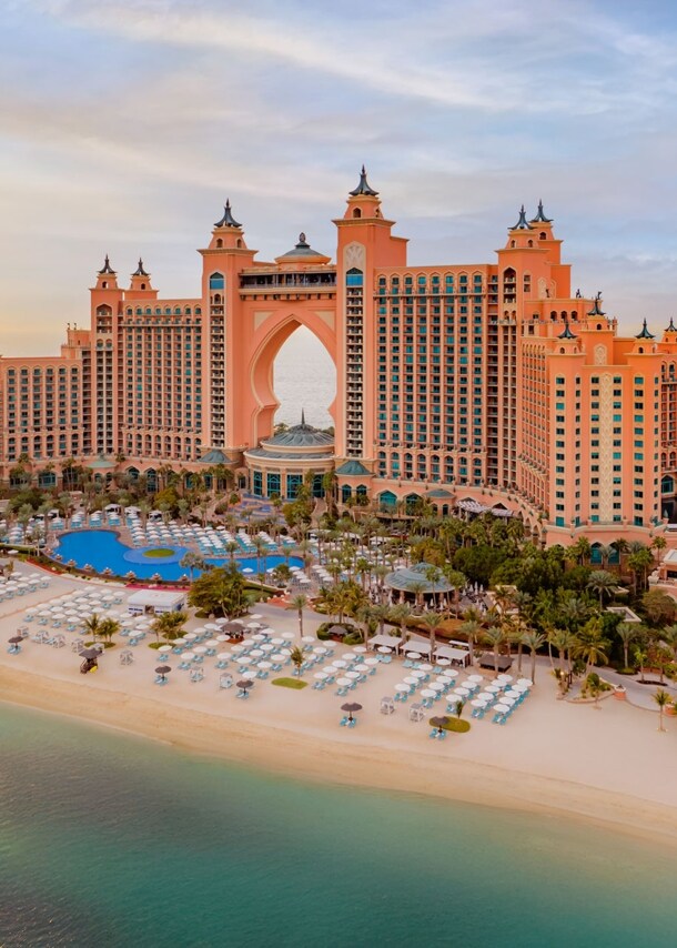Luxuriöser Hotelkomplex mit Türmen auf einer Insel mit Gartenanlage und Pool an weißem Sandstrand.