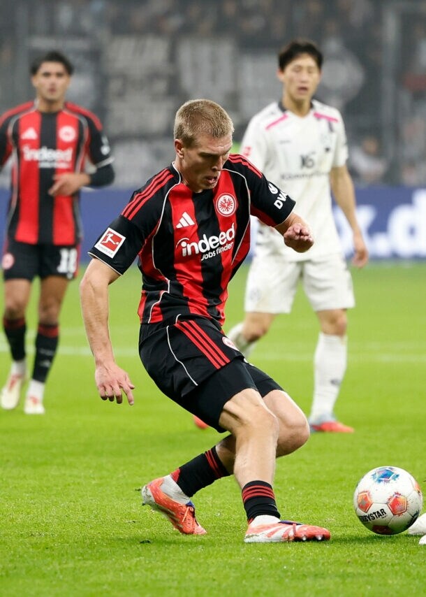 Zwei Fußballspieler gegnerischer Mannschaften im Ballduell auf dem Rasen in einem Fußballstadion.
