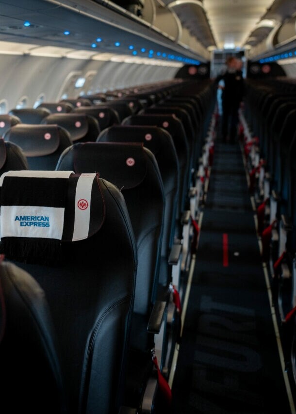 Sitzplätze eines Condor Business-Class-Fluges mit einem Fanschal der Eintracht Frankfurt über der Lehne.
