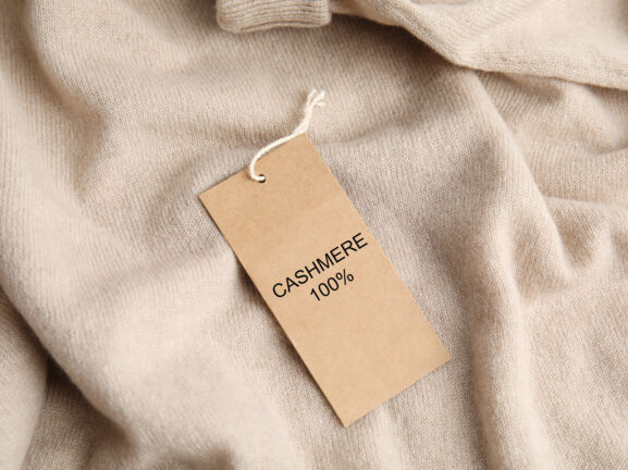 Ein Kaschmir-Pullover mit Etikett, auf dem „Cashmere 100 %” steht.