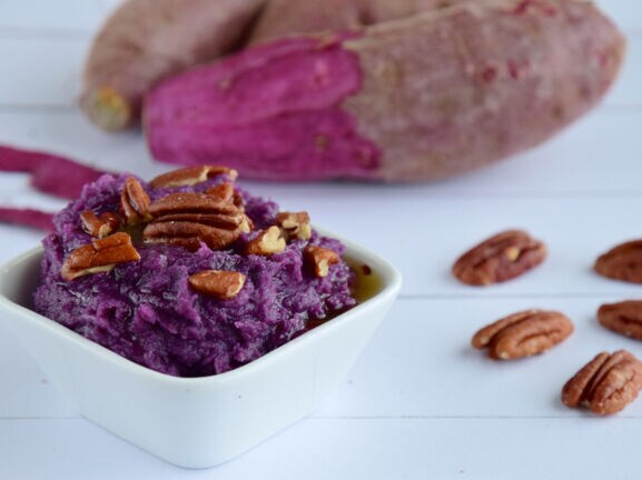 Nahaufnahme eines Stapels lila Yamswurzeln