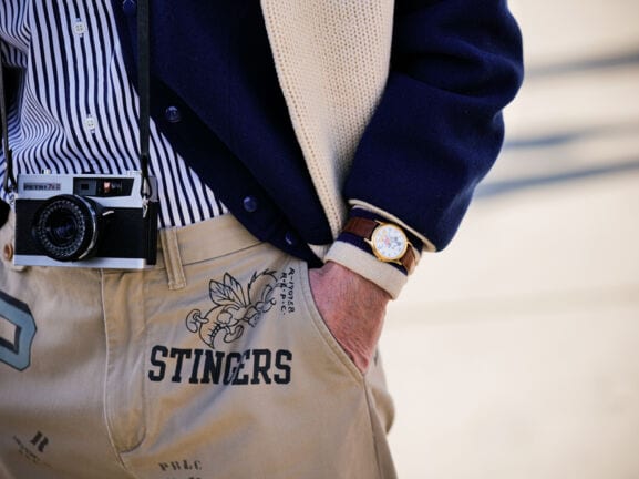 Detailaufnahme eines Mannes mit modischen Accessoires und Kamera