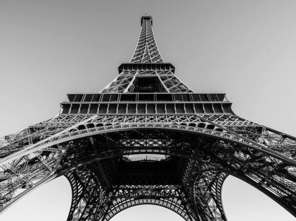 Schwarzweißaufnahme des Eiffelturms aus der Froschperspektive