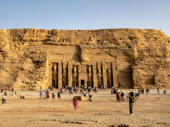 Besucher vor der Tempelanlage Abu Simbel mit in den Felsen geschlagenen Skulpturen
