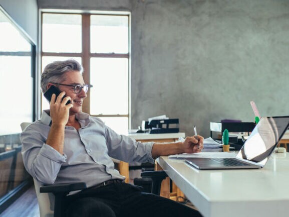 Ein Geschäftsmann telefoniert in seinem Büro.