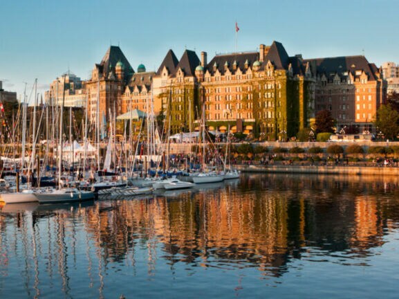 Boote vor dem historischen Fairmont Empress Hotel im Inner Harbour an einem klaren sonnigen Tag.