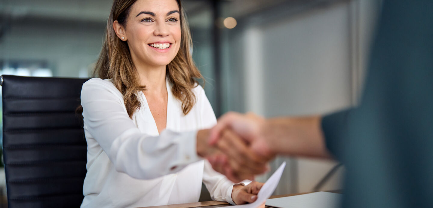 Frau schüttelt einem Bewerber die Hand