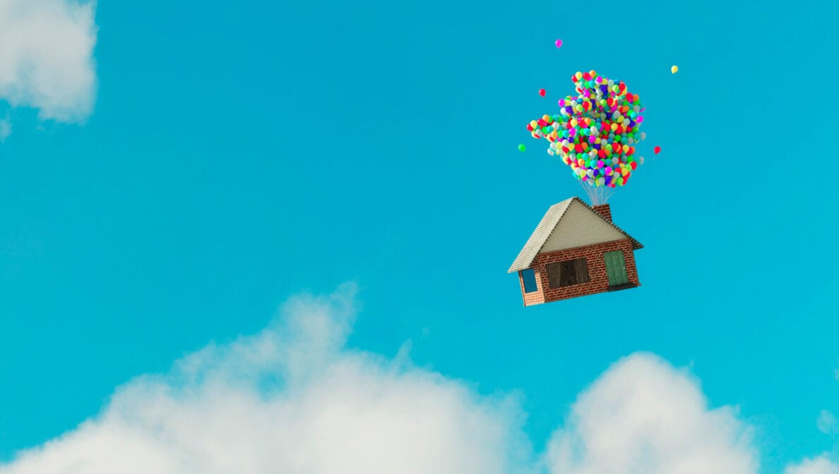 Haus fliegt mit Ballons durch blauen Himmel