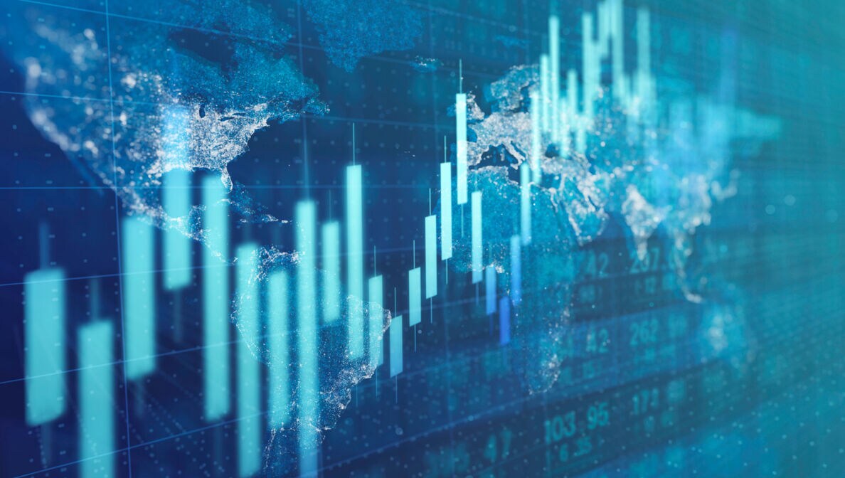 Auf einem Display abgebildete Aktienkurse mit einer Weltkarte im Hintergrund