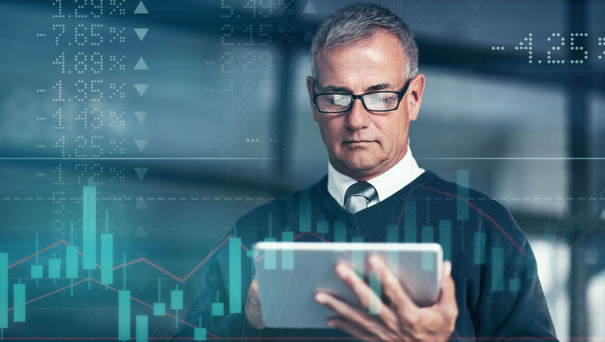 Mann in Hemd und Krawatte, der auf ein Tablet blickt