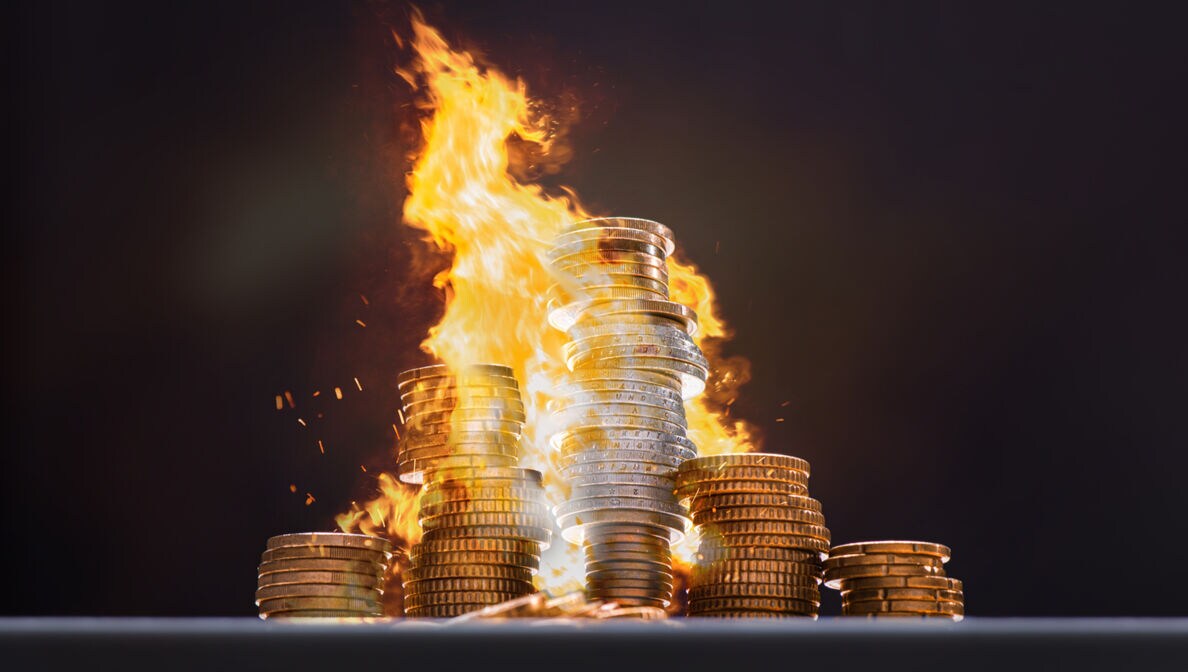 Mehrere Stapel Münzgeld stehen in Flammen