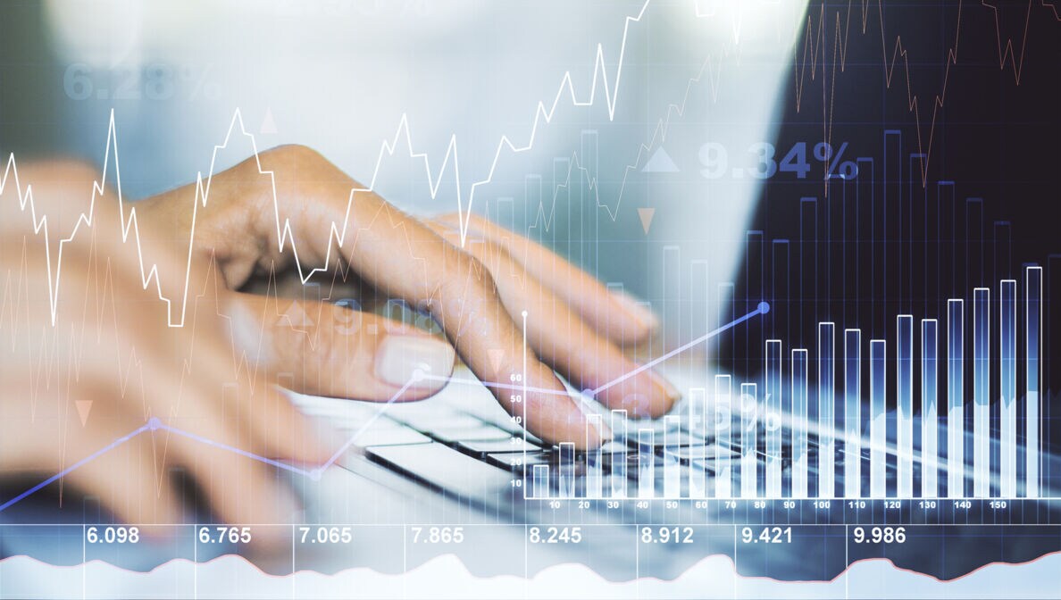 Abstraktes Finanzdiagramm und im Hintergrund Hände, die auf einem Laptop tippen