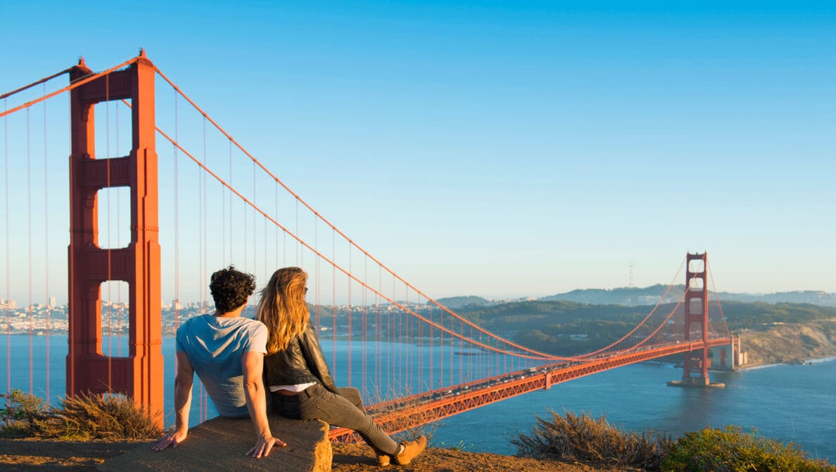 Eine Frau und ein Mann schauen gemeinsam auf die Golden Gate Bridge in San Francisco, USA.
