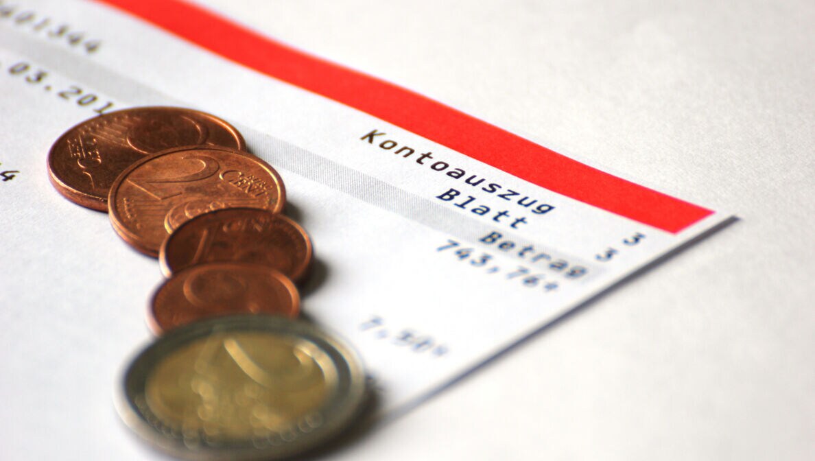 Euromünzen liegen auf einem Kontoauszug