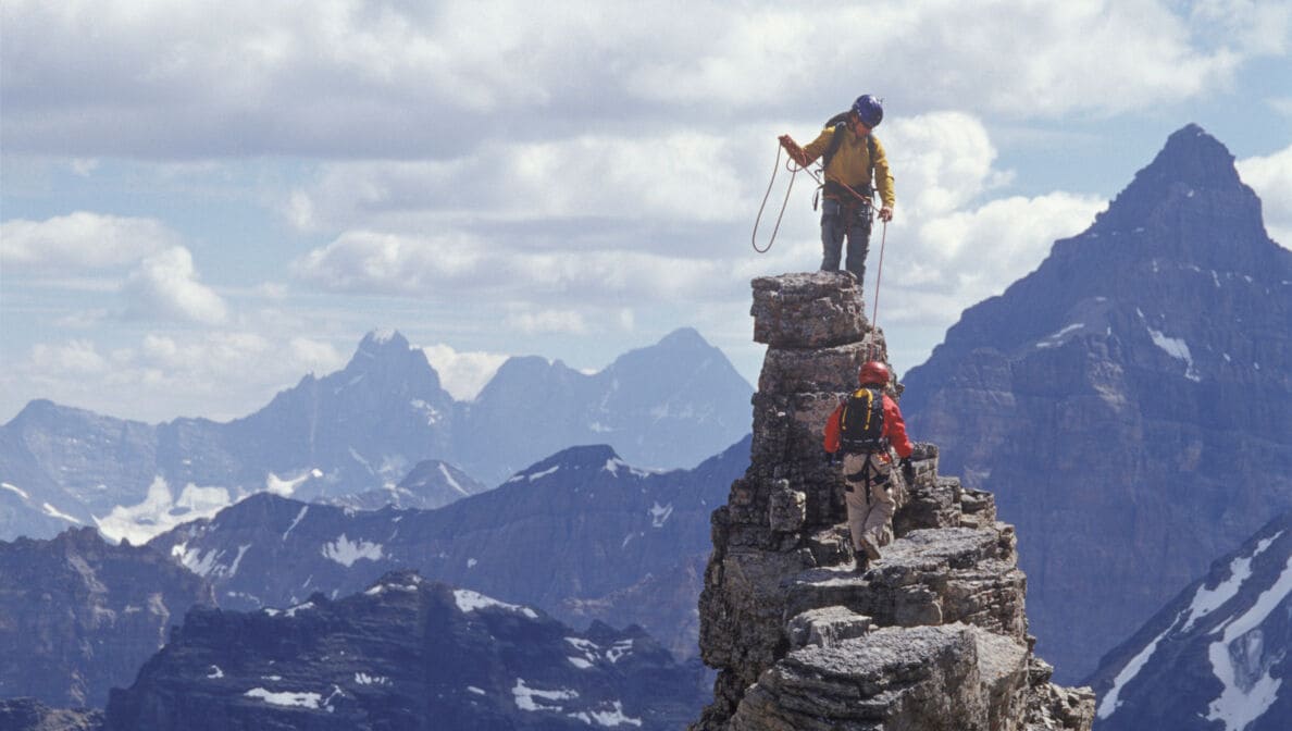 Zwei Kletterer beim Erreichen der Bergspitze