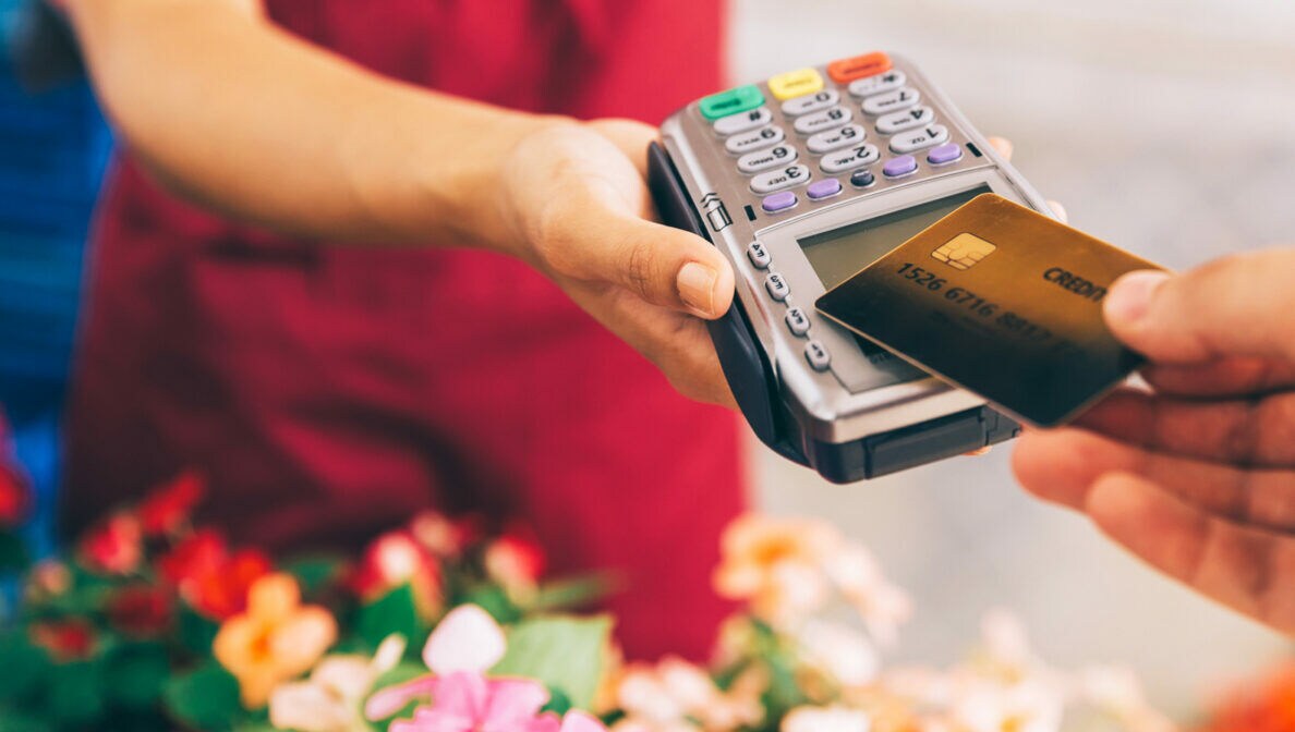 In einem Blumenladen wird der Kauf mit einer Karte bargeldlos mithilfe eines Kartenlesegeräts bezahlt.