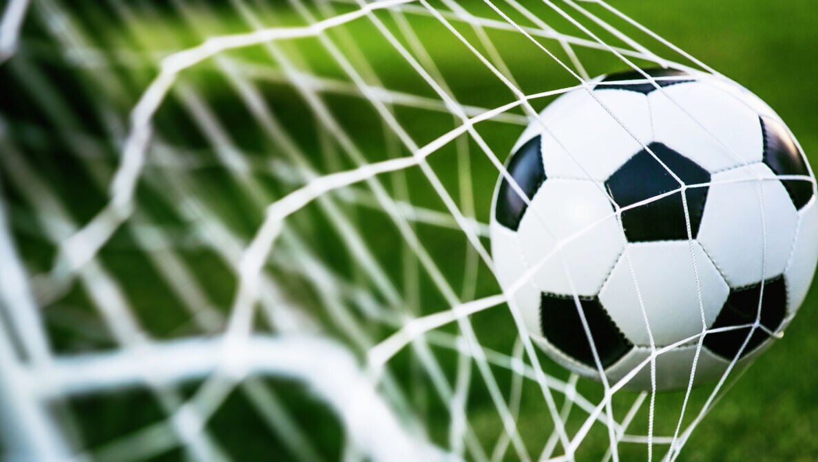 Fußball, der mit Schwung ins Tornetz fliegt