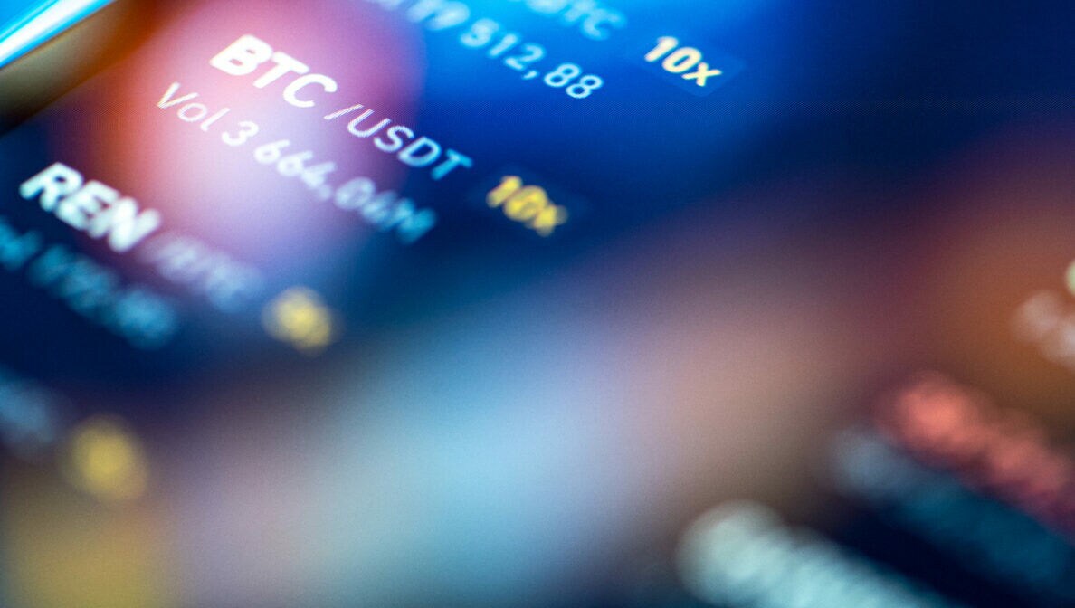 Detailaufnahme eines Displays mit Börsenabkürzungen von Kryptowährungen.