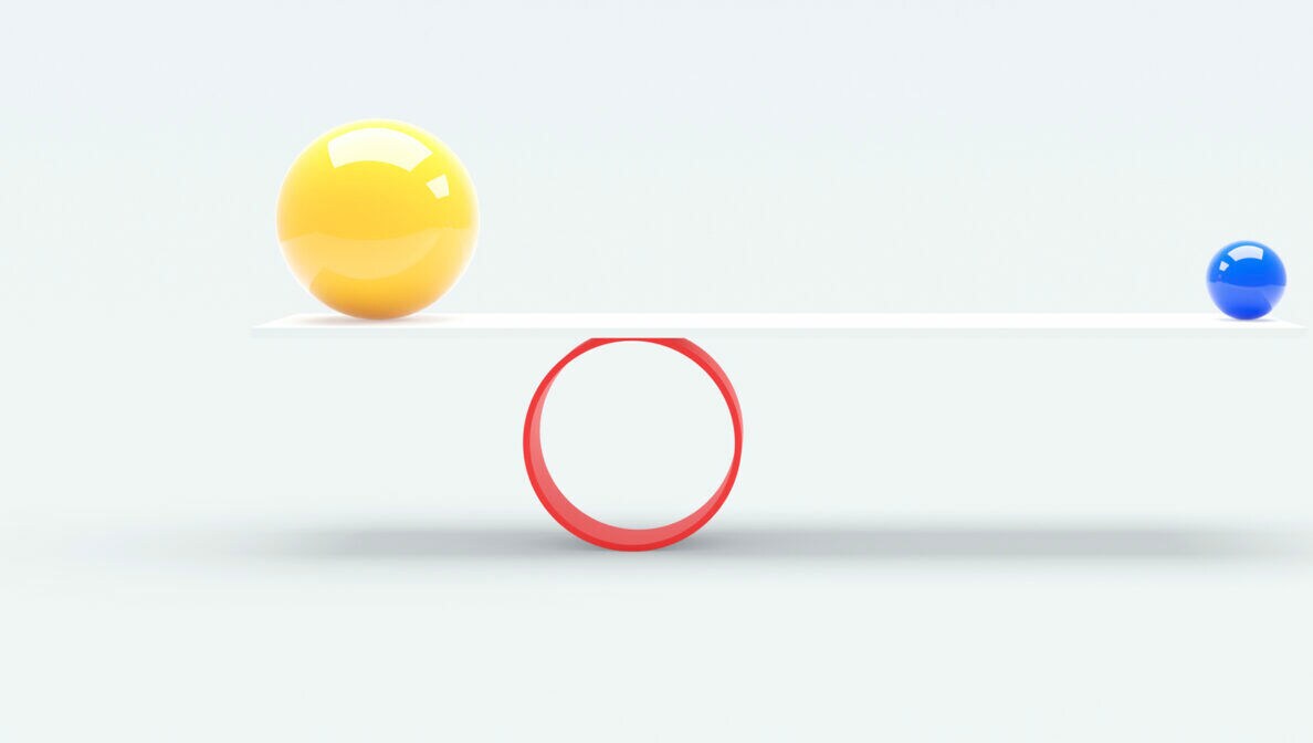 Eine große und eine kleine Kugel balancieren dank der Hebelwirkung auf einer Ebene auf einem Rad.