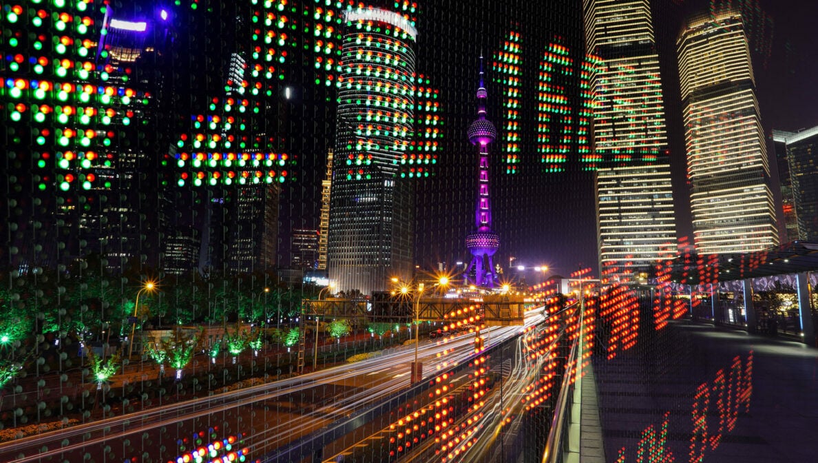 Shanghai bei Nacht, über das ein digitaler Börsenkurs gelegt wurde.