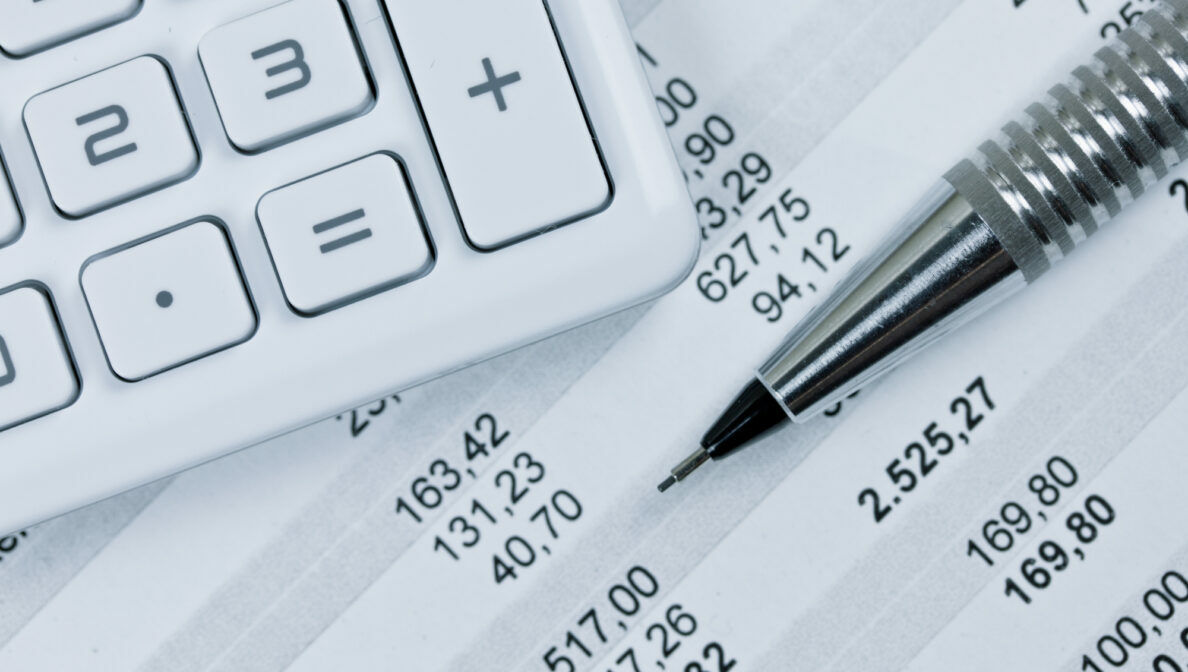 Ein Taschenrechner und ein Stift liegen auf einem Kontoauszug