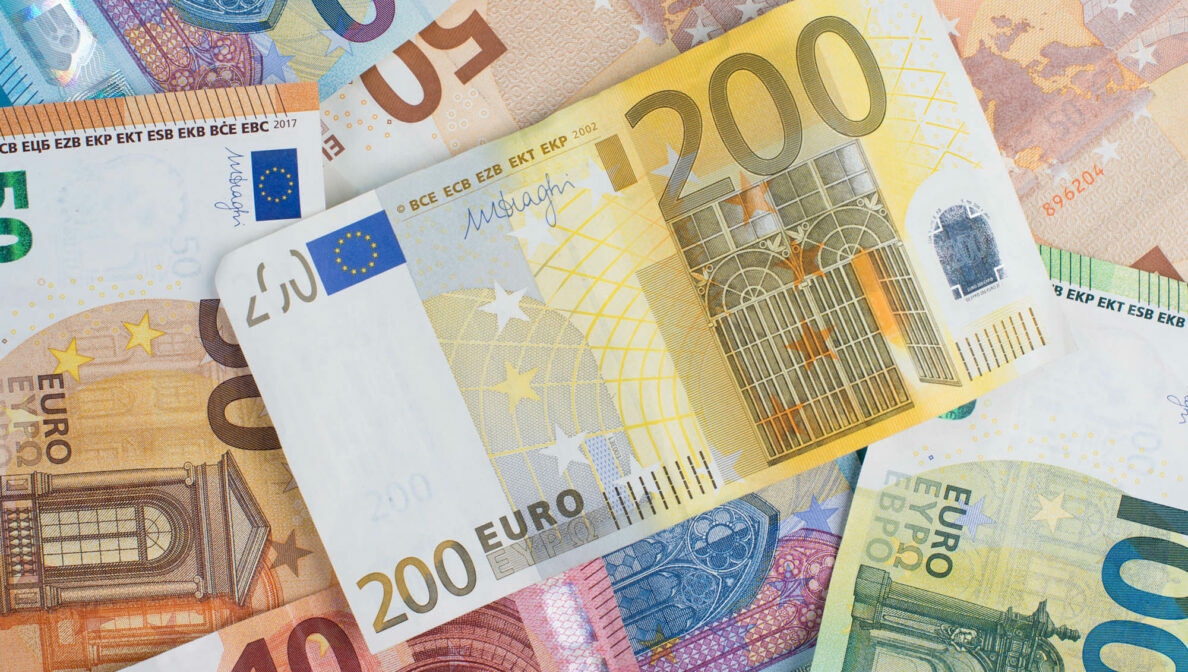 Mehrere Euroscheine liegen verteilt auf einem unbekannten Untergrund