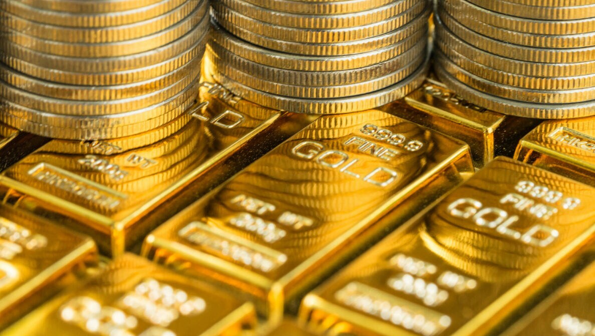 Drei Münzstapel stehen auf auf mehreren Goldbarren