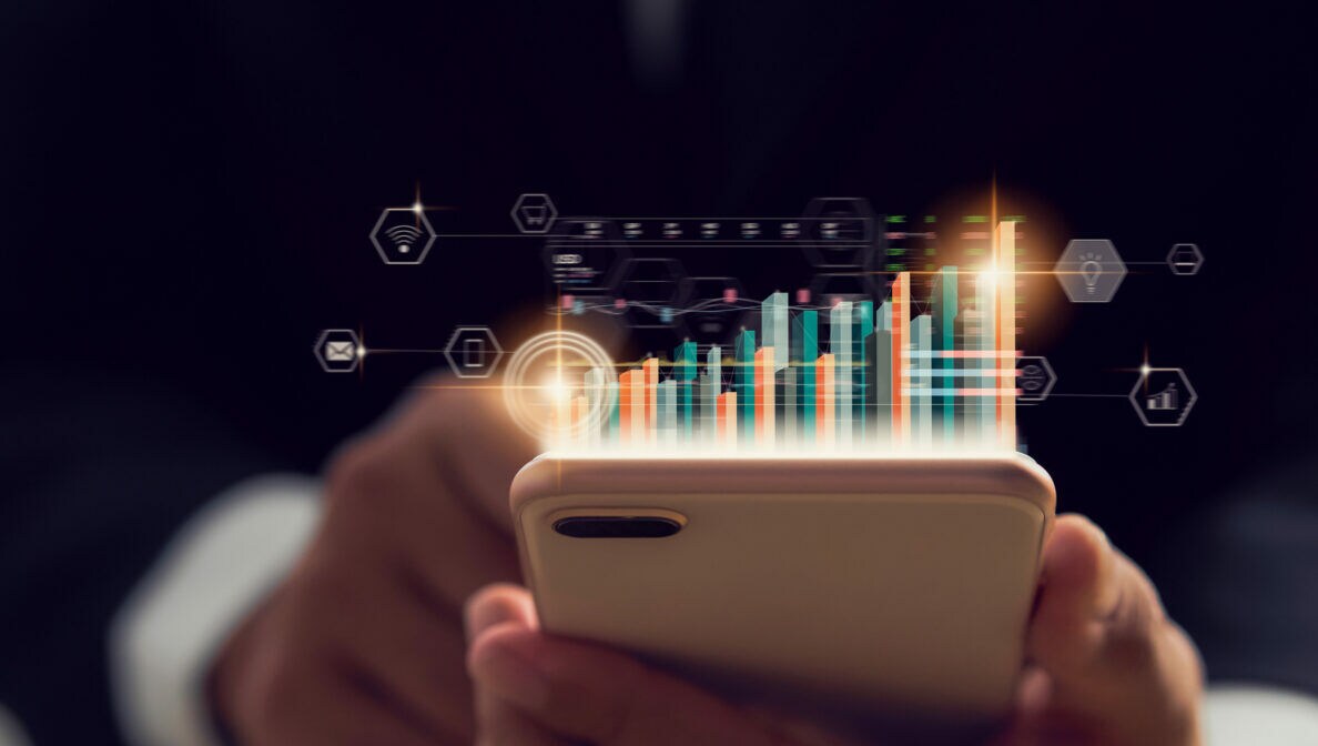 Eine Person, die ein Smartphone in der Hand hält, über dem eine Illustration eines Balkendiagramms mit verschiedenen Kursen dargestellt ist