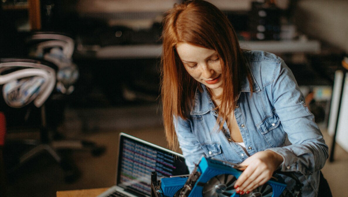 Eine Person baut mehrere Grafikkarten in ein Computer ein