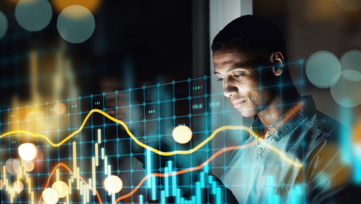 Eine Person blickt auf ein Laptop, über dem Bild liegt ein digitales Aktienchart.