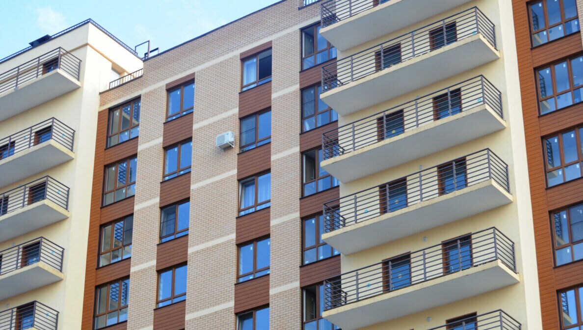 Eine Fassade eines mehrstöckigen Hauses mit Balkonen.