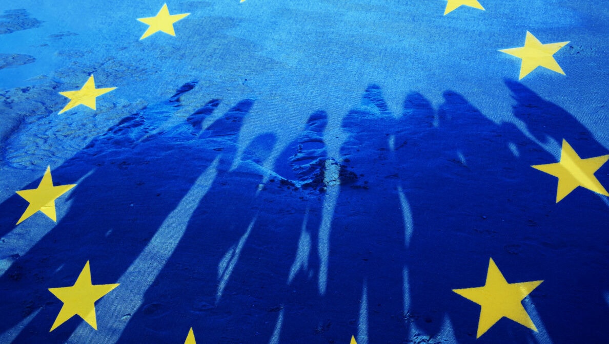 EU-Flagge, auf der der Schatten einer Gruppe Menschen zu sehen ist.