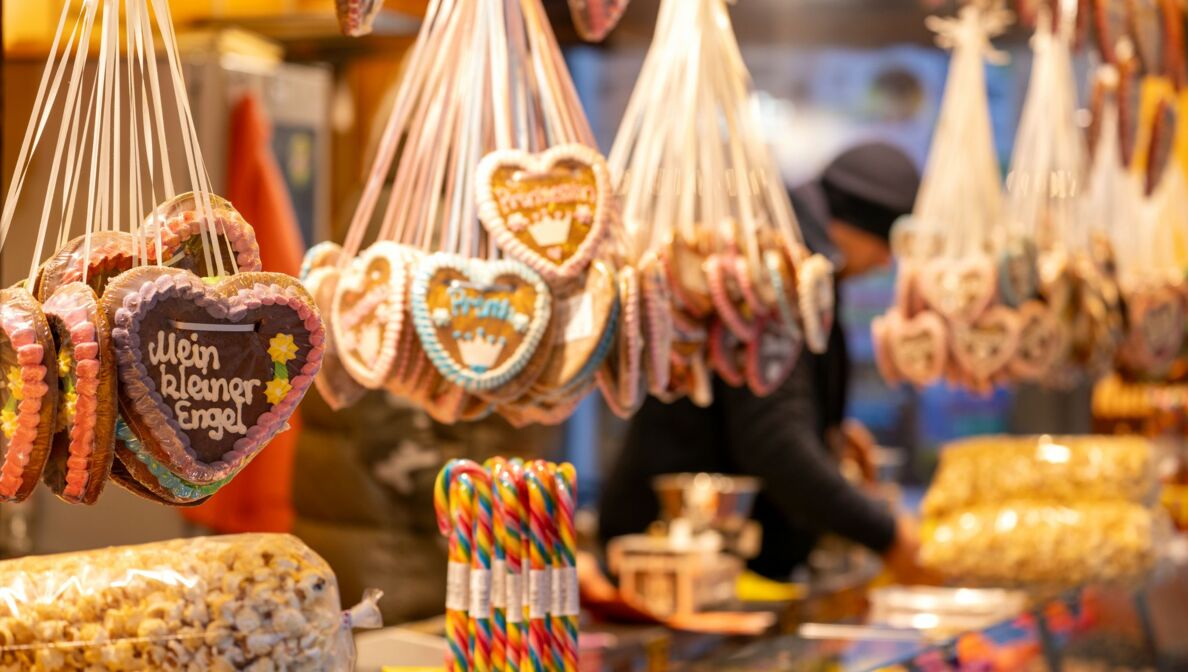 Die Aufschrift "Mein kleiner Engel" ist auf einem Lebkuchenherz zu lesen, im Hintergrund packt ein Verkäufer eine Tüte mit Süßigkeiten. Das Bayreuther Winterdorf verbreitet bereits vor dem Aufbau des offiziellen Weihnachtsmarktes weihnachtliche Stimmung. (zu dpa: «Alkohol, Süßes und Fleisch: Ladenhüter nach dem Fest»)