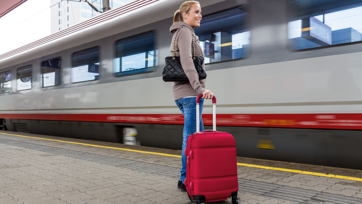 Bild: Person wartet mit Koffer am Bahnsteig