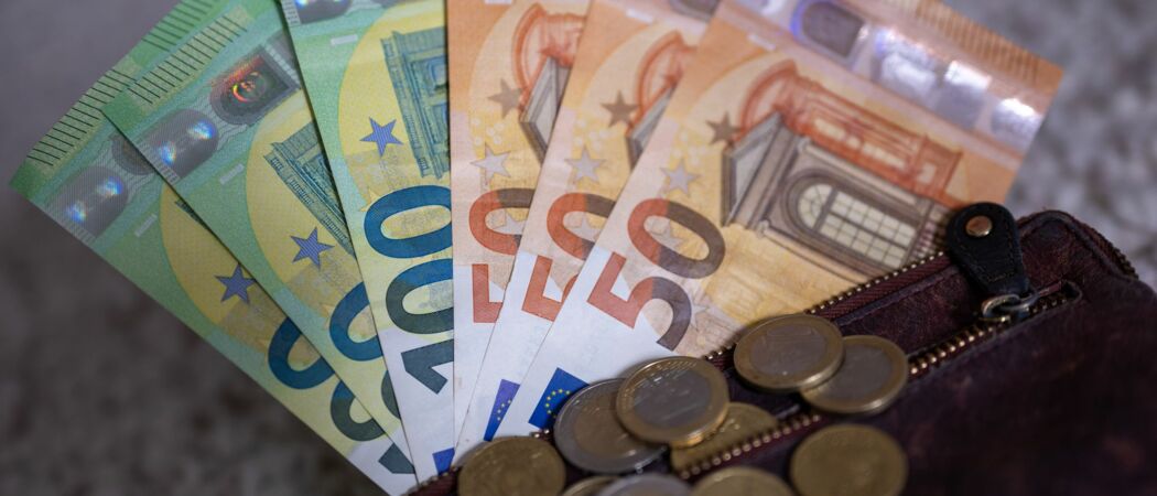 Geldscheine mit dem Wert von 100 und 50 Euro stecken in einem Geldbeutel, während auf dem Geldbeutel Münzen liegen. (zu dpa: «Jeder Dritte kann sich Abkehr vom Bargeld vorstellen»)