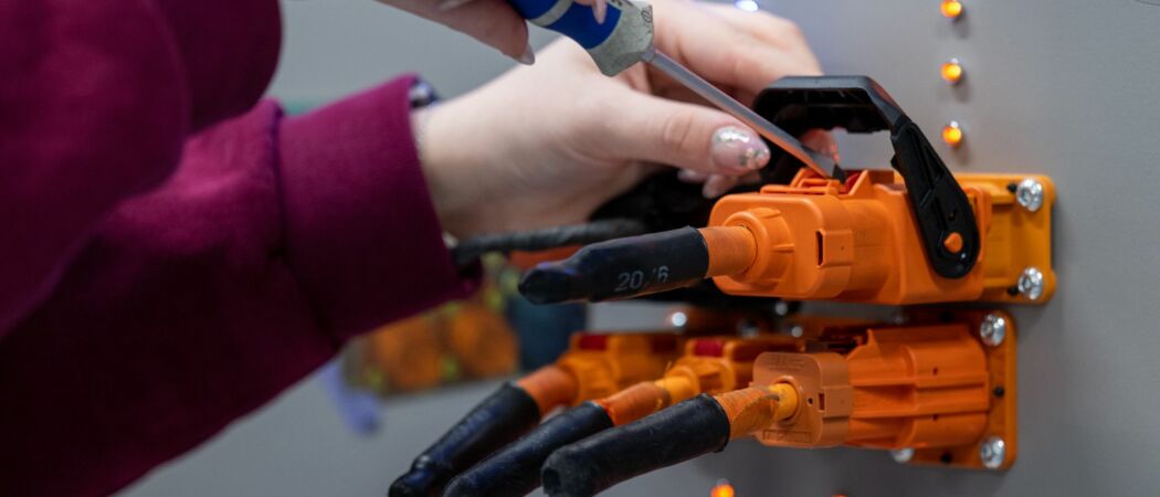 Eine angehenden KfZ-Mechatronikerin überprüft im Volkswagen Bildungsinstitut in Zwickau Stecker für ein Ladegerät. (zu dpa: «Studie: Frauen füllen Lücken im Handwerk»)