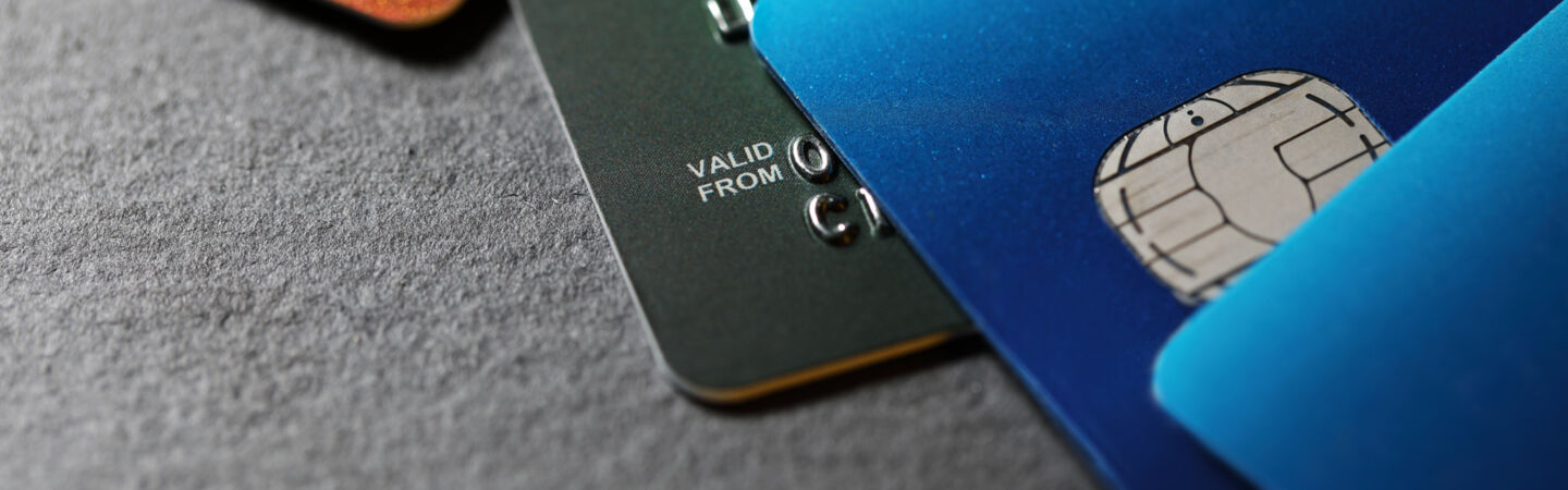 Nahaufnahme von vier unterschiedlich farbigen Kreditkarten, die versetzt übereinander liegen.