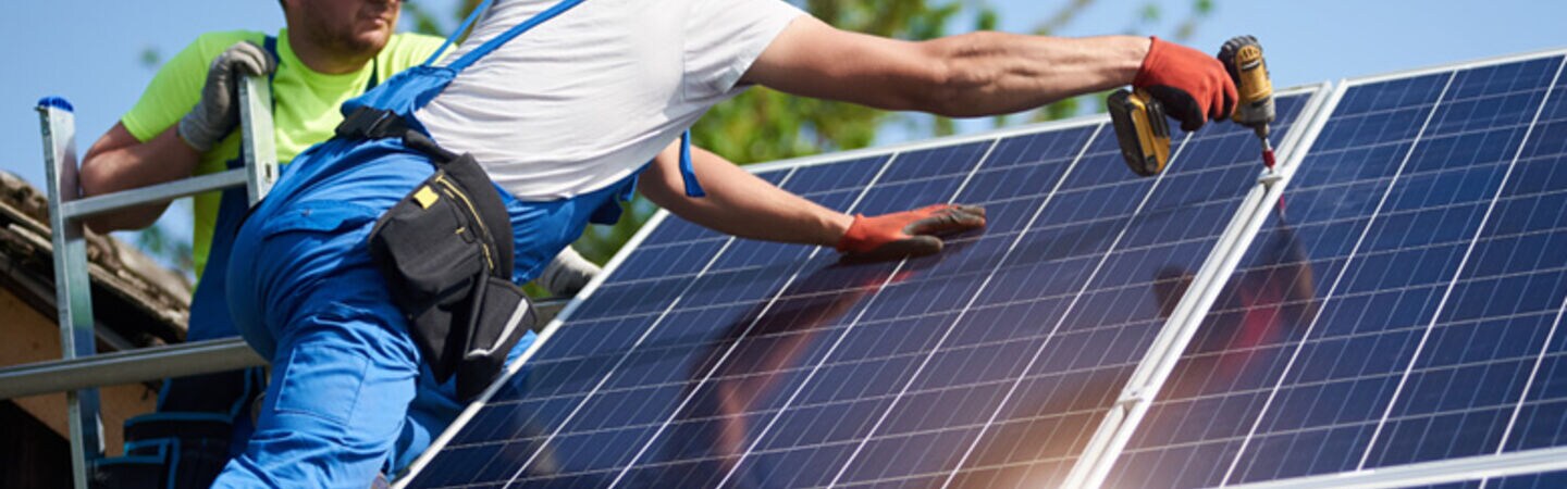 zwei Männer arbeiten an einer Solaranlage