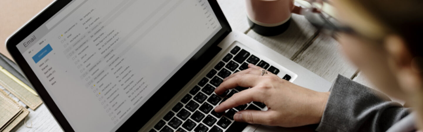 Eine Person tippt auf ihrem Laptop.