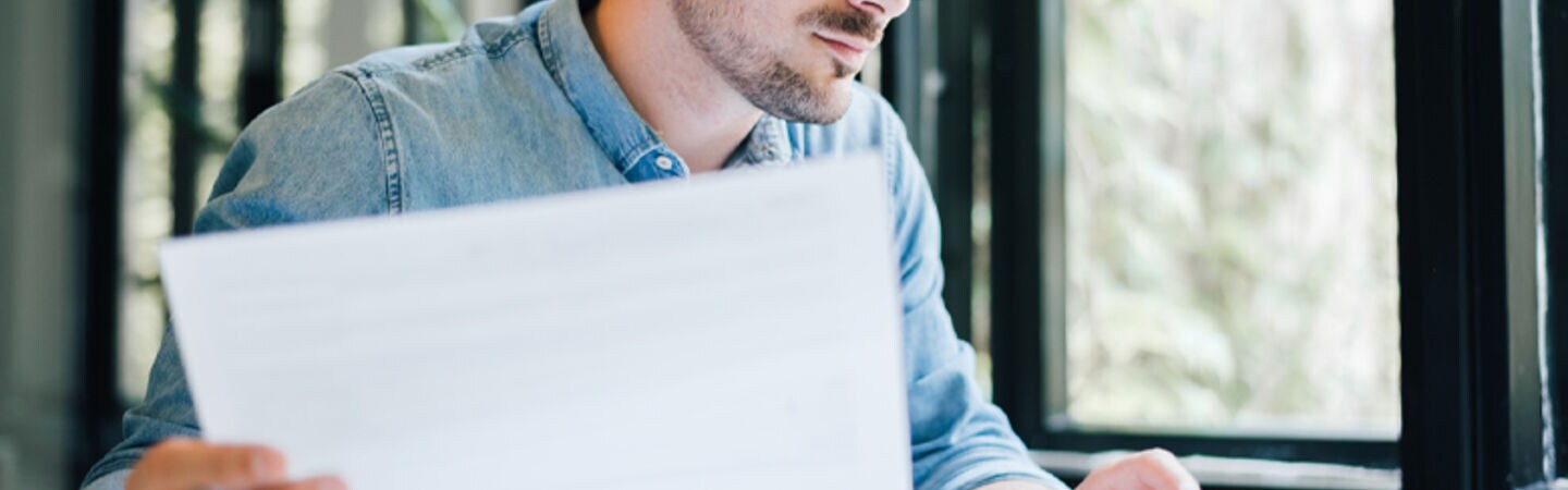 Mann untersucht am Computer die Unterlagen.